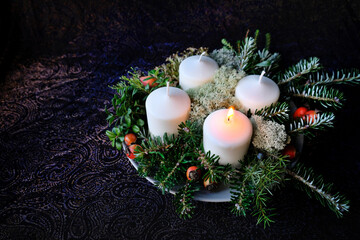 The first candle in an Advent wreath is lit - the anticipation of Christmas has begun