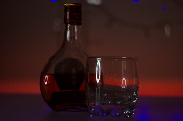 
Half-empty bottle of cognac and glass glass empty