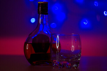 
Half-empty bottle of cognac and glass glass empty