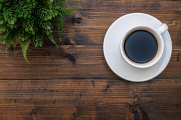 Top view of white coffee cup on wooden background