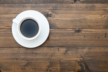 Top view of white coffee cup on wooden background