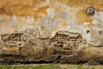 Old yellow plaster and brick wall
