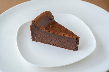 Slice of chocolate cheese cake on white plate