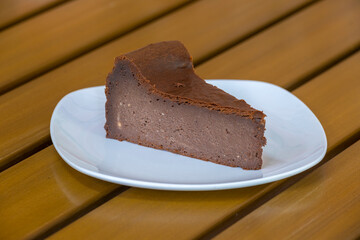 Slice of chocolate cheese cake on white plate