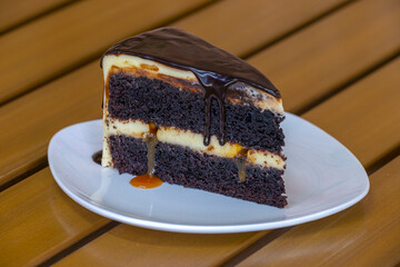 Slice of caramel chocolate cheese cake on white plate