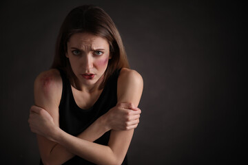 Woman with facial injuries on black background, space for text. Domestic violence victim