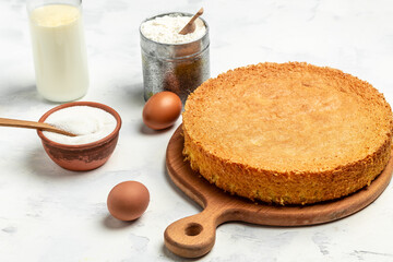 Homemade sponge cake with ingredients on a white wooden table. Bakery background concept. banner, menu recipe place for text