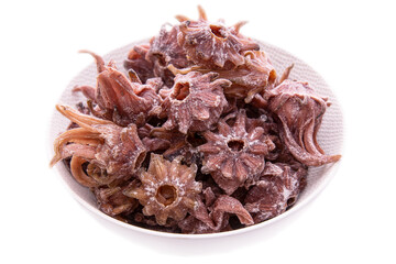 Hibiscus in sugar in a light plate on a white background.