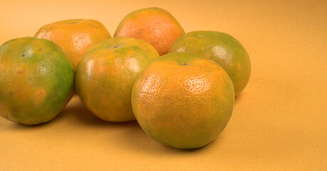 Fresh orange citrus fruit with leaves isolated on yellow background. Juicy and sweet and renowned for its concentration of vitamin C.