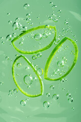 Aloe vera slice texture with gel on green background. Medicinal plant. Flat lay. Top view. Natural herbal medical plant, skincare, healthcare and beauty spa concept.