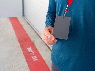 Man with badge on red ribbon stays on pit lane at autodrom. Sports car racing. Sports competition on special track.