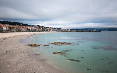 Panorama view of Sanxenxo and Silgar beach at the end of a cloudy Spring day in the Rias Baixas in Galicia, Spain. Long exposure.