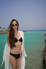 beautiful girl on the beach, on the sea, posing on the beach, rest on the sea. High quality photo