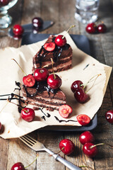 Two pieces of cake with fresh cherries.