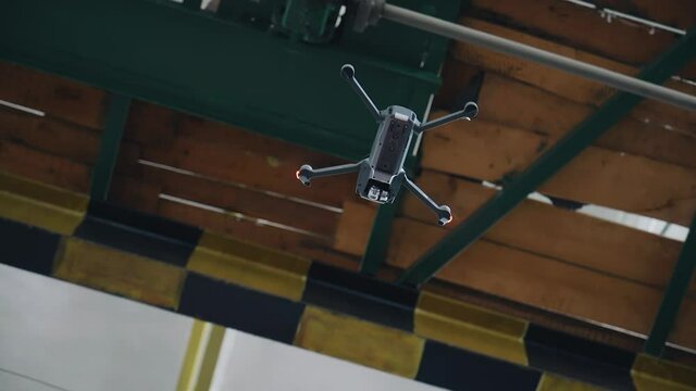 The Quadcopter Hovered Under The Ceiling Of The Workshop In The Enterprise. The Camera Shoots The Drone From Below