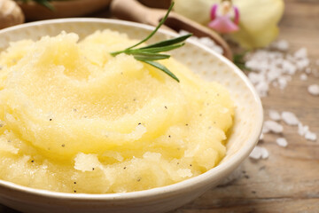 Body scrub with rosemary in bowl on table, closeup