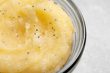 Body scrub in glass jar on light grey background, closeup