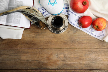Flat lay composition with Rosh Hashanah holiday attributes on wooden table. Space for text