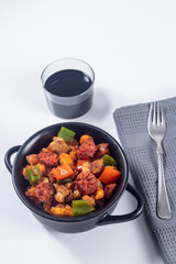 Extremadura crumbs, breadcrumbs, sausage, bacon, red and green peppers, garlic and paprika, with a glass of wine. Concept of traditional home cooking. Vertical photo and selective focus