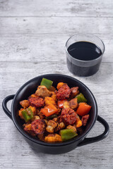 Extremadura crumbs, breadcrumbs, sausage, bacon, red and green peppers, garlic and paprika, with a glass of wine. Concept of traditional home cooking. Horizontal photo and selective focus