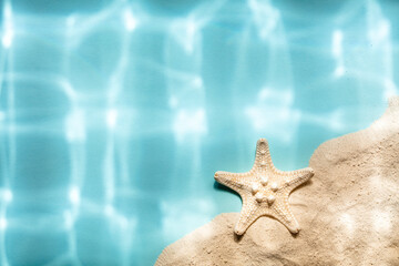 Fototapeta na wymiar White Starfish and sand on blue background with underwater ripped shadows, top view, copy space