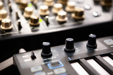 Synthesizer piano and mixer in sound recording studio. Professional musical instrument and analog...