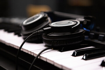Professional headphones on synthesizer piano keyboard in sound recording studio. Listen to the...