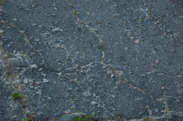 rough concrete surface with grass in cracks