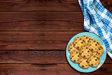 Chocolate Chip Cookies in plate on wood table with checkered napkin