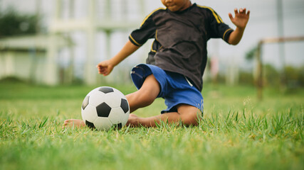 Obraz premium Action sport outdoors of kids having fun playing soccer football for exercise at the green grass field.