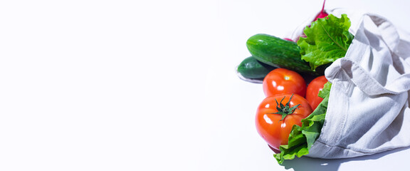fresh vegetables, lettuce leaves in a shopping bag on a white background. Top view, flat lay. Banner