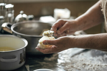 close-up view of hands making delicious pies with dough