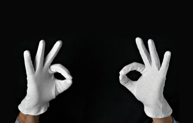 hands with white gloves make ok gesture, isolated on black background