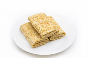 Rolled-up pancakes on a plate on a white background.