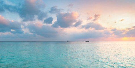 Fototapeta na wymiar Amazing wide panorama of tropical Maldives island. Exotic beach background with blue lagoon, turquoise water and palm trees during beautiful sunrise. 