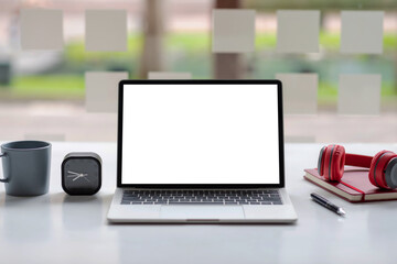 Fototapeta premium Laptop computer blank white screen and headphones placed at a white desk. Mock up.