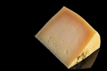Portion of cured manchego cheese on black background. Horizontal shot