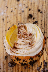 cupcake of cinnamon and lemon cream sponge cake on wooden background. Vertical shot