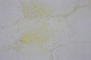 Frosty yellow old paint on a gray wall.