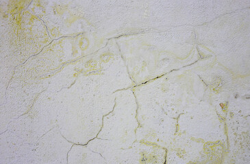 Frosty yellow old paint on a gray wall.