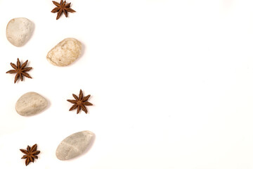 White background with natural elements: stones and anise stars