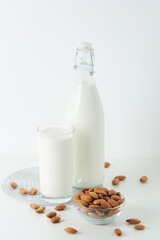 A glass with almond milk and the bowl with almonds