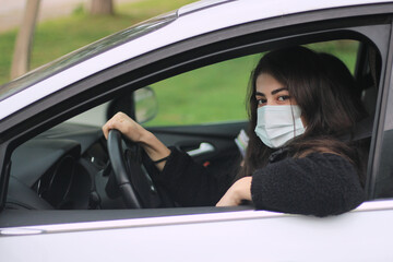 Smiling woman driving car,Woman wearing a protection face mask in a car.