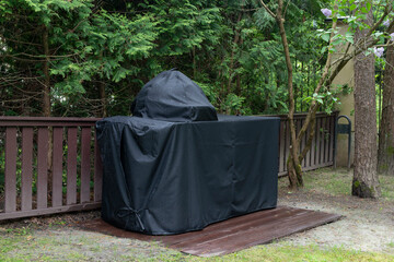 Barbeque grill Cover protecting kamado-style ceramic grill from rain.