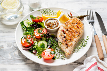 Grilled chicken breast with fresh vegetable salad. Healthy food, keto diet, diet lunch concept.  White wooden background.	
