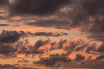 atardecer anaranjado con nubes grises en la costa