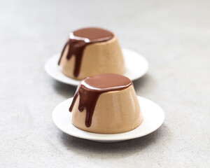 Panna Cotta coffee with chocolate on a plate on a light gray background