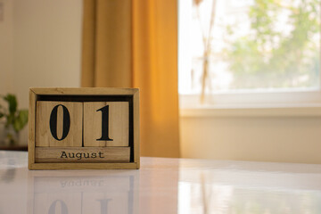 Wooden blocks of the calendar represents the date 1 and the month of August on the background of a...