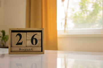 Wooden blocks of the calendar represents the date 26 and the month of August on the background of a...