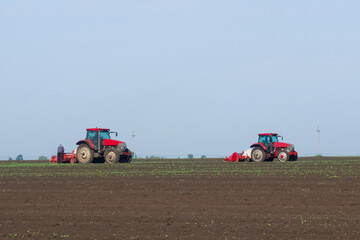 Two tractors working in an agricultural field